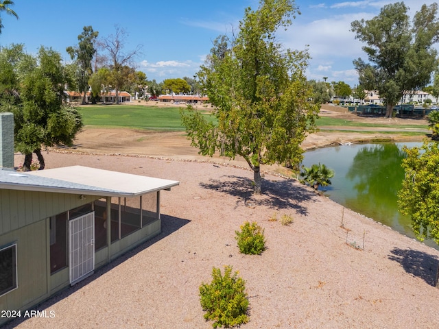 view of yard with a sunroom and a water view