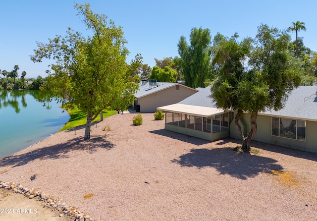 view of yard with a sunroom and a water view