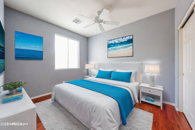 bedroom featuring visible vents, baseboards, a closet, and wood finished floors