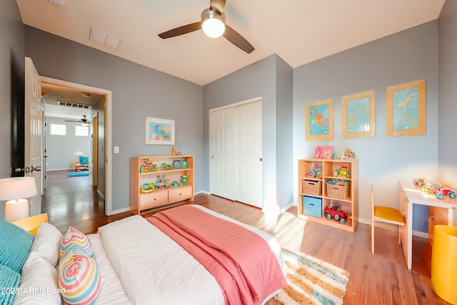 bedroom featuring a closet, visible vents, baseboards, and wood finished floors