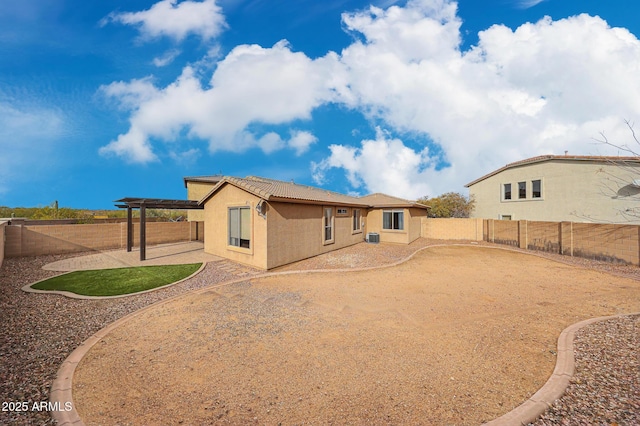 rear view of house featuring a tile roof, stucco siding, cooling unit, a fenced backyard, and a patio