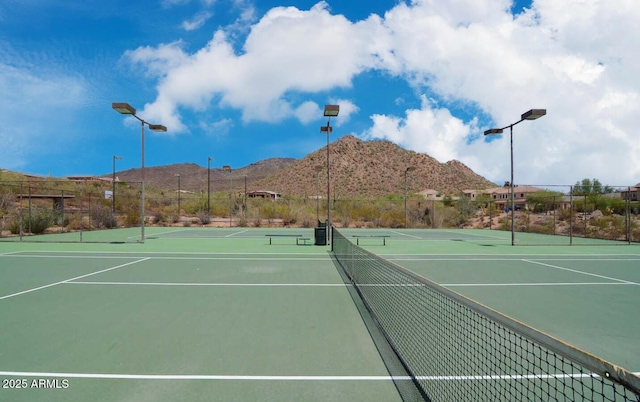 view of sport court with a mountain view and fence