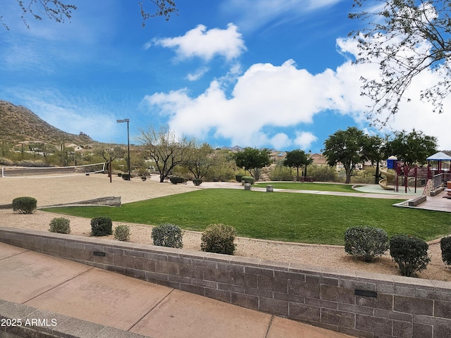 view of property's community featuring playground community, a lawn, and volleyball court