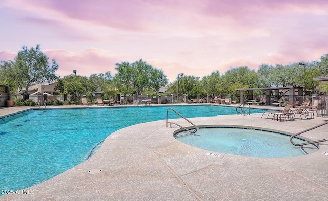 community pool with a patio area and fence