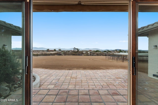 view of patio / terrace featuring a mountain view and a rural view