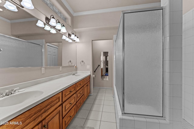 bathroom featuring a sink, a stall shower, crown molding, and tile patterned floors