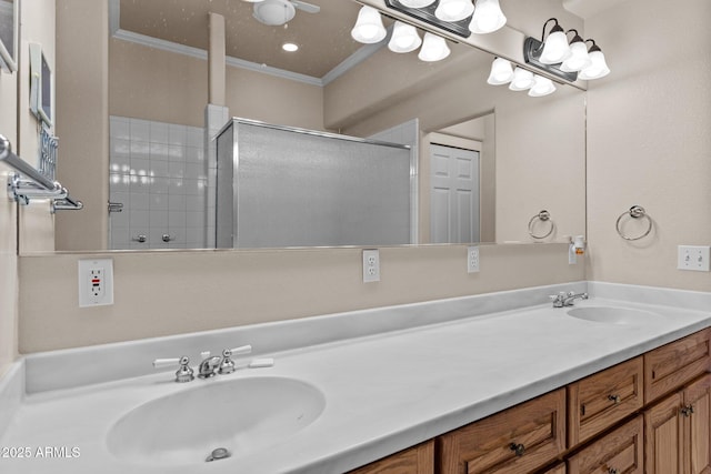 bathroom with a sink, a shower with door, ornamental molding, and double vanity