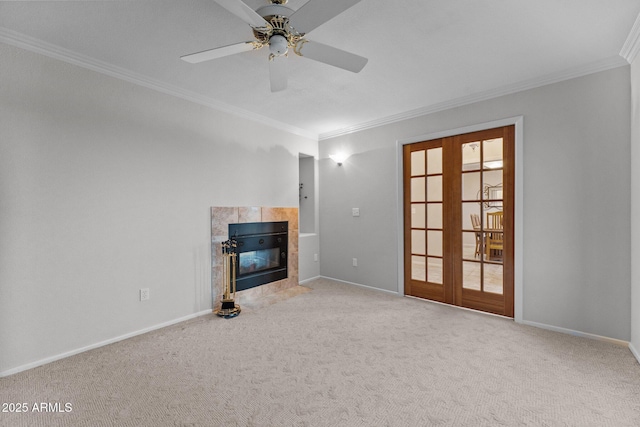 unfurnished living room featuring a tile fireplace, baseboards, carpet, and french doors