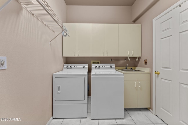 laundry area featuring independent washer and dryer, a sink, cabinet space, light tile patterned floors, and baseboards