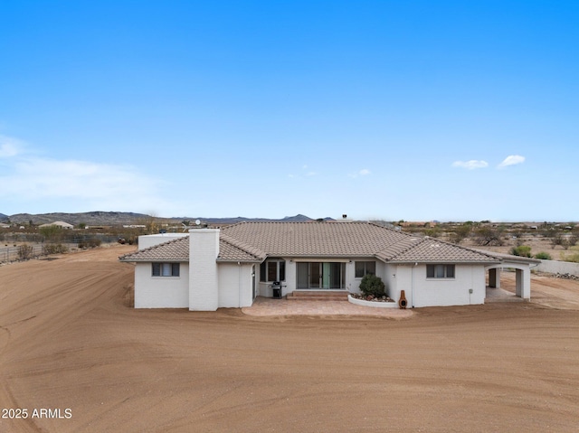 view of front of house featuring a tiled roof and stucco siding