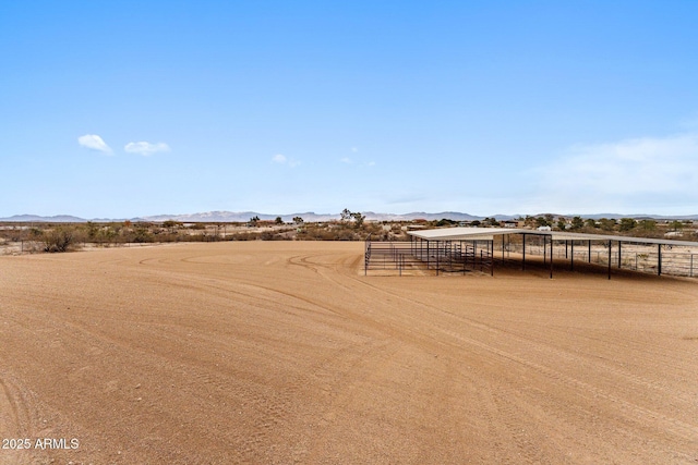 view of yard featuring an outdoor structure, a rural view, and a mountain view