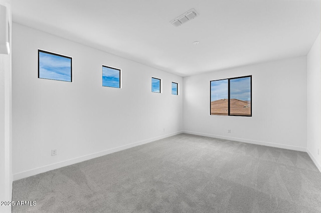 unfurnished room featuring baseboards, carpet floors, and visible vents