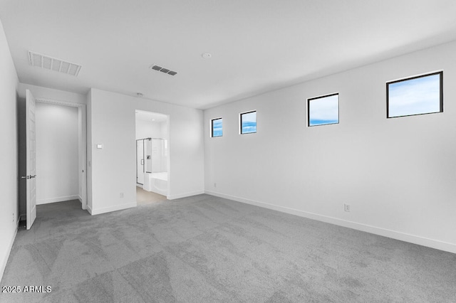unfurnished bedroom featuring ensuite bathroom, baseboards, visible vents, and carpet