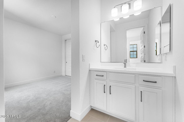 bathroom with baseboards, tile patterned flooring, and vanity