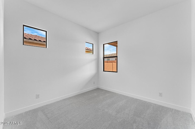 empty room featuring baseboards and carpet flooring