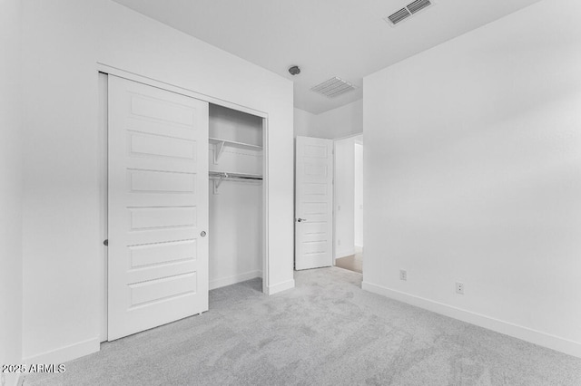 unfurnished bedroom with carpet flooring, baseboards, a closet, and visible vents