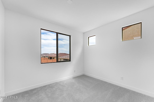 carpeted spare room featuring baseboards