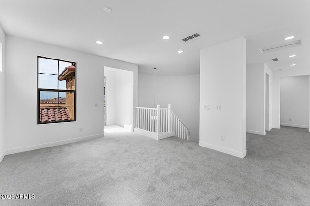 carpeted empty room with baseboards, visible vents, and recessed lighting