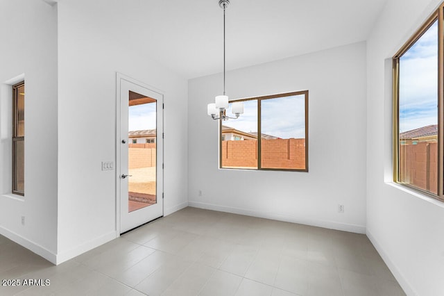 unfurnished dining area featuring baseboards and a notable chandelier