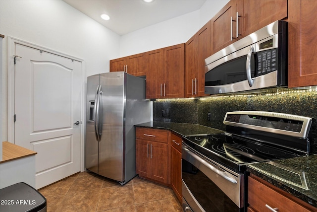11640 N Tatum Blvd Unit 3091, Phoenix, AZ 85028 - kitchen featuring dark stone counters, dark tile patterned flooring, appliances with stainless steel finishes, and decorative backsplash
