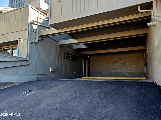 exterior space featuring a garage and brick siding