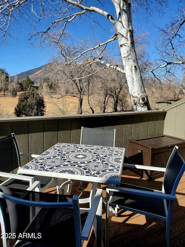 deck featuring outdoor dining space and a mountain view