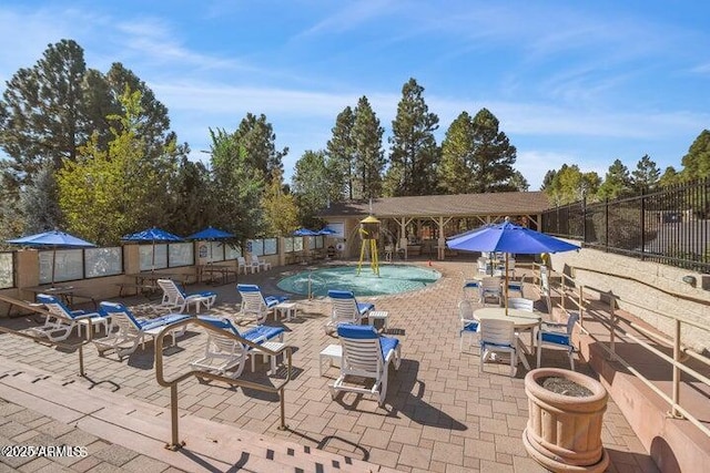 community pool featuring a patio area and fence