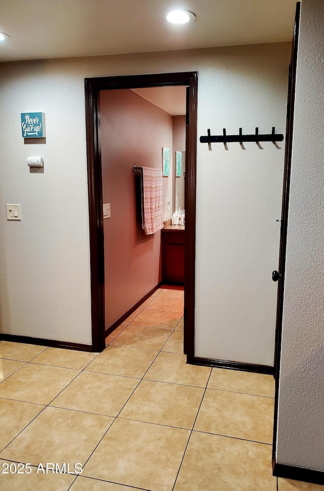 hallway featuring recessed lighting, light tile patterned flooring, and baseboards