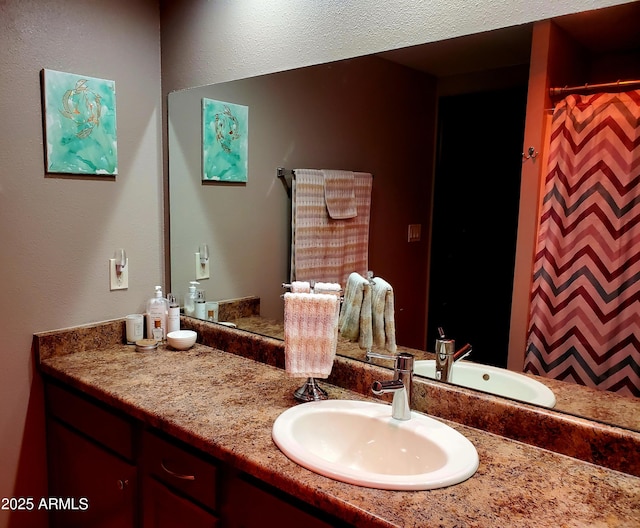 bathroom with curtained shower and vanity