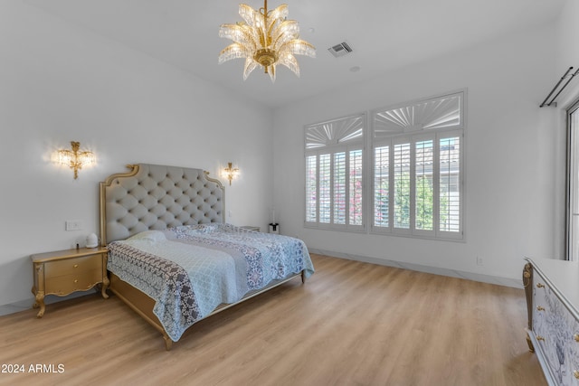 bedroom featuring a chandelier and light hardwood / wood-style floors