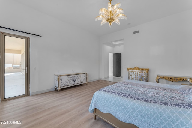 bedroom with an inviting chandelier and hardwood / wood-style flooring