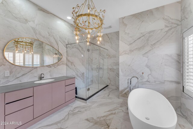 bathroom with vanity, independent shower and bath, tile walls, and a notable chandelier