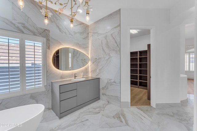 bathroom with vanity, a healthy amount of sunlight, tile walls, and a washtub