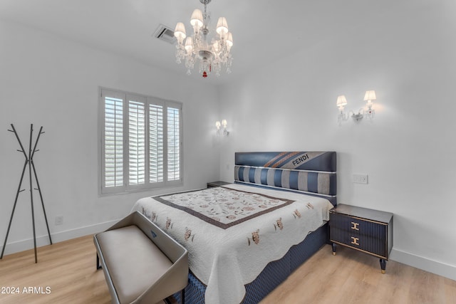 bedroom with hardwood / wood-style floors and a chandelier