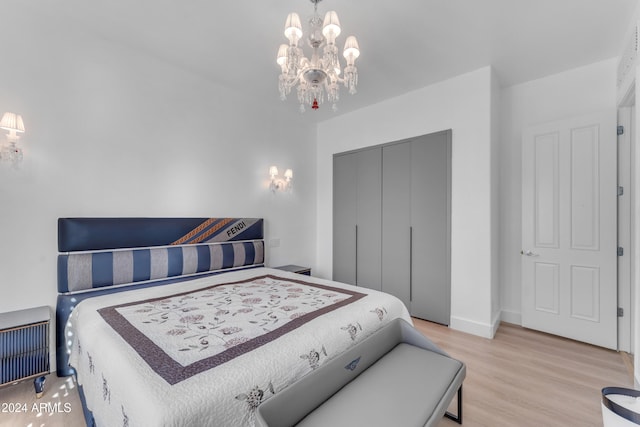 bedroom featuring a chandelier, a closet, and light hardwood / wood-style flooring