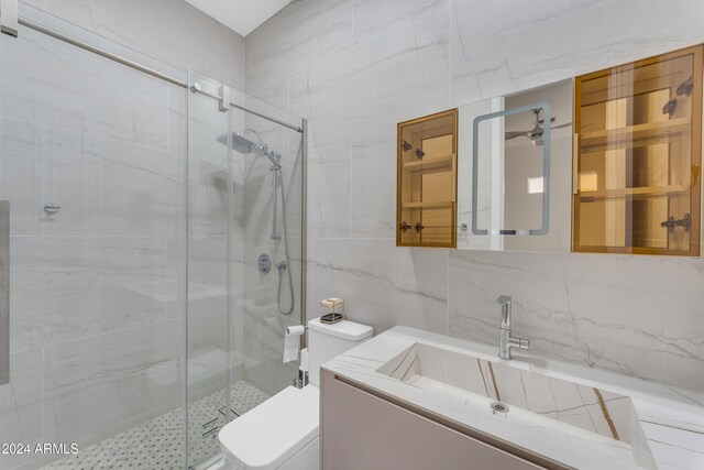 bathroom featuring tile walls, tasteful backsplash, and a shower with door