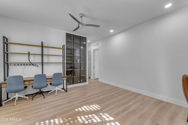 unfurnished office with light hardwood / wood-style floors and ceiling fan