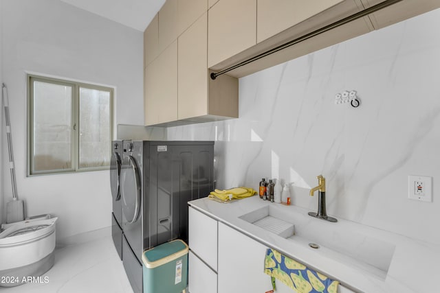 laundry room featuring washer and clothes dryer, cabinets, and sink