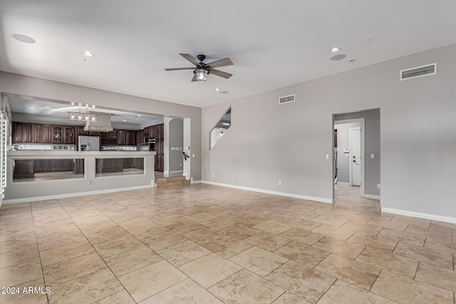 unfurnished living room with ceiling fan with notable chandelier