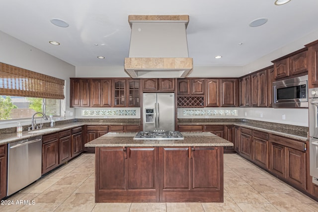 kitchen featuring sink, appliances with stainless steel finishes, a center island, and dark brown cabinetry