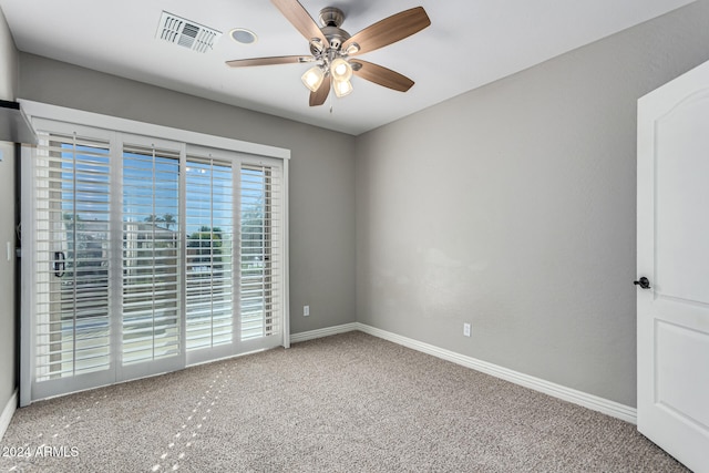 empty room featuring ceiling fan and carpet