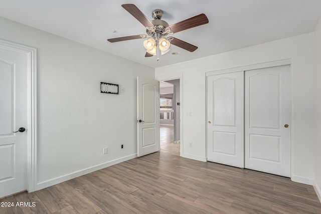 unfurnished bedroom with a closet, light hardwood / wood-style floors, and ceiling fan