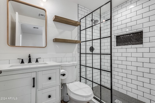 bathroom featuring vanity, toilet, and tiled shower