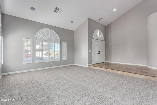 interior space featuring carpet flooring and high vaulted ceiling