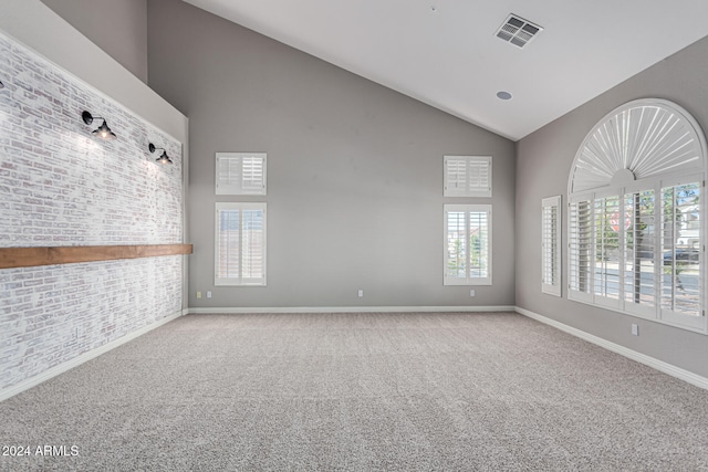 carpeted spare room with high vaulted ceiling and a wealth of natural light