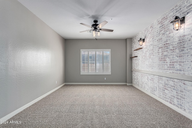 spare room with ceiling fan, brick wall, and carpet floors