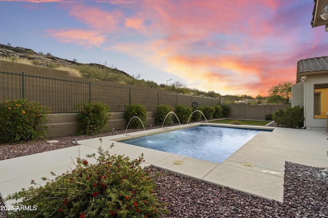 3551 W Hidden Mountain Ln, Anthem, AZ 85086 - pool at dusk with a patio, a fenced in pool, and a fenced backyard