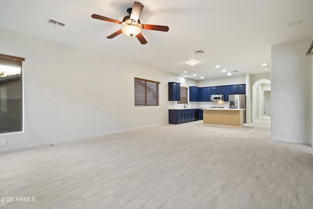 3551 W Hidden Mountain Ln, Anthem, AZ 85086 - unfurnished living room featuring arched walkways, a ceiling fan, light wood finished floors, and visible vents