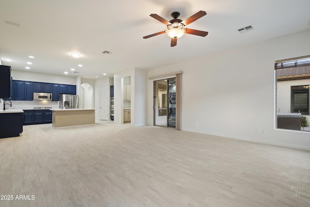 3551 W Hidden Mountain Ln, Anthem, AZ 85086 - unfurnished living room featuring a sink, ceiling fan, visible vents, and light wood-style flooring