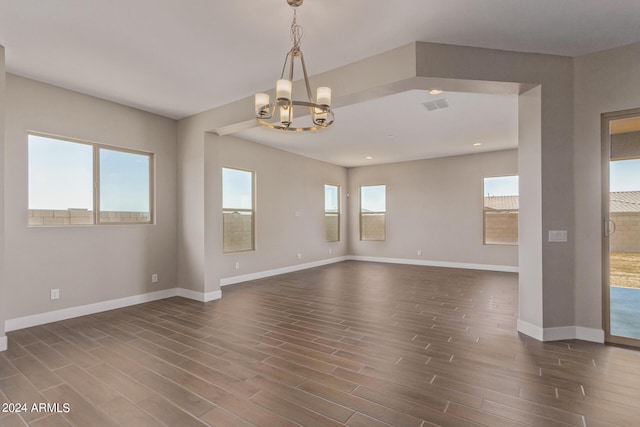 empty room featuring dark hardwood / wood-style floors and a chandelier